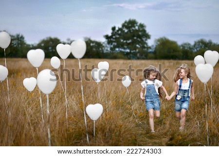 portrait of a little girls in a field with white balloons
