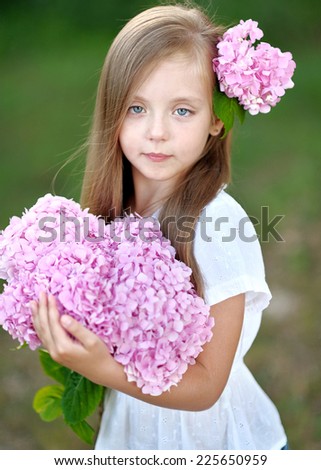 portrait of little girl with flowers hydrangea