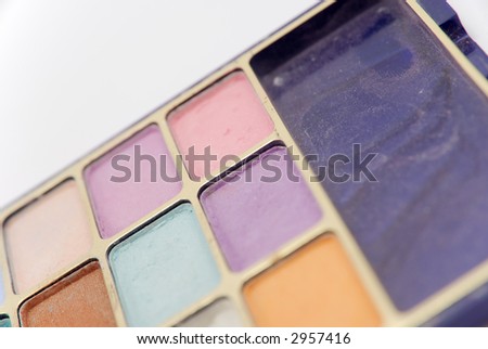 Set of multicolored eye-shadows isolated on white background. Shallow depth of field.