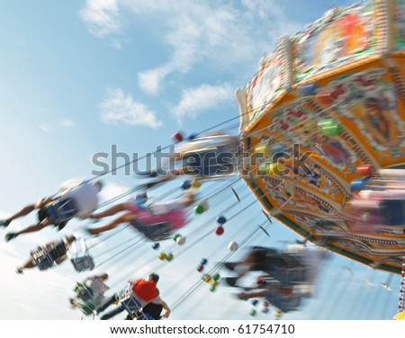 People enjoying the ride in a classic Chair-O-Planes at the fair