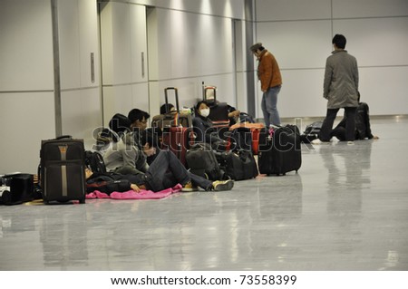 NARITA AIRPORT, JAPAN - MARCH 18 : People spend the night at Narita airport in Tokyo on March 18, 2011. Some wait for delayed or cancelled flights, others want to make sure they catch their flight.