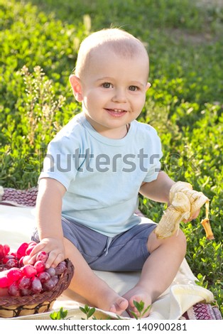 Beautiful little baby boy eats banana