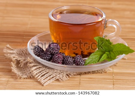 Fruit tea(tea package) in cup with blackberry
