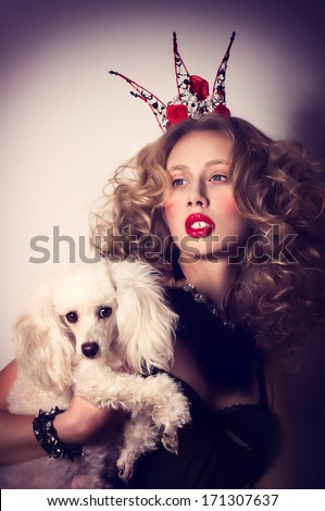 Young fashionable queen with crown and mantle with dog