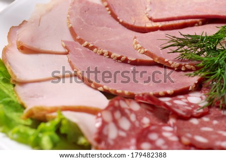Cutting bacon, sausage and cured meat on a celebratory table