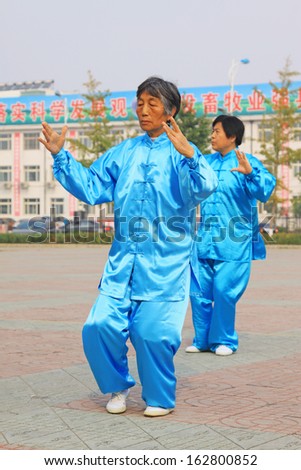LUANNAN COUNTY - OCTOBER 20: A group of old people is performing Tai chi chuan on the gym in the square, on October 20, 2011, LuanNan county, hebei province, China