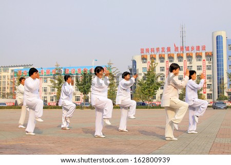 LUANNAN COUNTY - OCTOBER 20: A group of old people is performing Tai chi chuan on the gym in the square, on October 20, 2011, LuanNan county, hebei province, China
