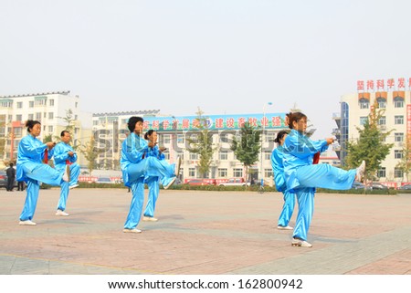 LUANNAN COUNTY - OCTOBER 20: A group of old people is performing Taiji sword on the gym in the square, on October 20, 2011, LuanNan county, hebei province, China