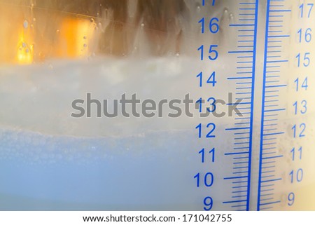 Ml scale on a glass milk storage tank, closeup of photo