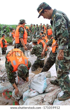 Luannan, August 4: Chinese armed police soldiers Stacked sandbags in flood danger area in Luanhe River levee small dam,  on August 4, 2012, Luannan, Hebei, China.