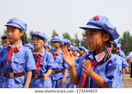LUANNAN COUNTY - JULY 16: The Elementary student dressed in blue military uniform standing on the playground, on July 16, 2012, luannan county, Hebei province, China