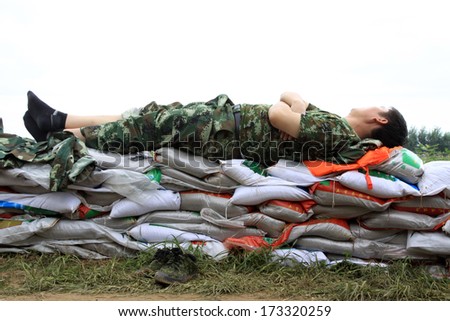 Luannan, August 4: Chinese armed police soldiers has a short rest on sandbag on August 4, 2012, Luannan, Hebei, China.