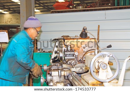 LUANNAN COUNTY, CHINA - NOVEMBER 22: Workers operating the machine tools in a factory november 22, 2012, Luannan county, hebei province, China