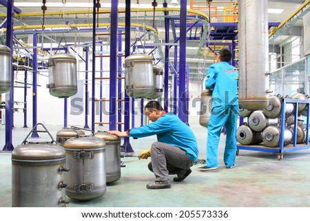 TANGSHAN CITY - MAY 29: Worker cleaning stainless steel pressure tank in a production workshop, on may 29, 2014, Tangshan city, Hebei Province, China
