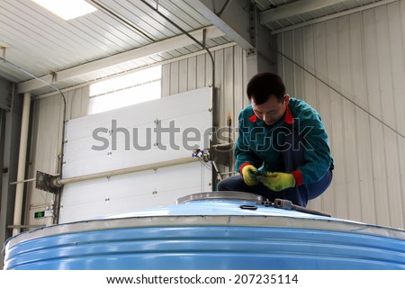 TANGSHAN CITY - MAY 29: Maintenance workers stainless steel shell of the solar water heater, in a production workshop, on may 29, 2014, Tangshan city, Hebei Province, China