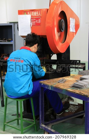 TANGSHAN CITY - MAY 29: Technical workers operating punch in a production workshop, on may 29, 2014, Tangshan city, Hebei Province, China