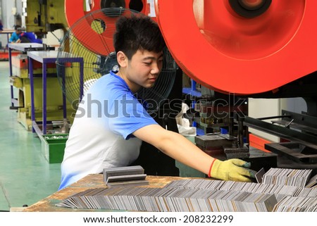TANGSHAN CITY - MAY 29: Technical workers operating punch in a production workshop, on may 29, 2014, Tangshan city, Hebei Province, China
