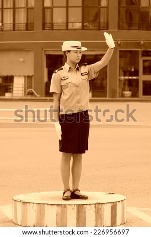 LUANNAN COUNTY - SEPTEMBER 16: Female traffic police directing traffic in the street on September 16, 2011, Luannan County, Hebei Province, China