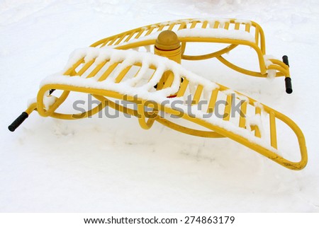 Yellow fitness facilities in the snow, closeup of photo