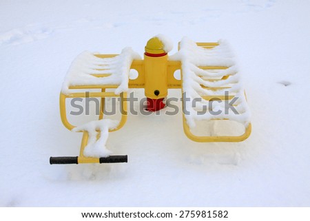 Yellow fitness facilities in the snow, closeup of photo