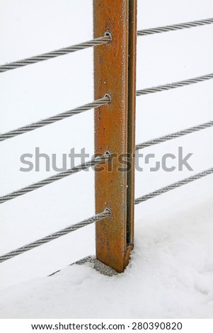 Wire rope and metal pillar in the frost and snow