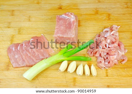 lean meat, onion and garlic on the chopping board