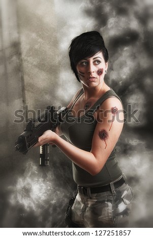 wounded special tactics sexy woman holding up her weapon in a battlefield