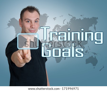 Young man press digital Training Goals button on interface in front of him