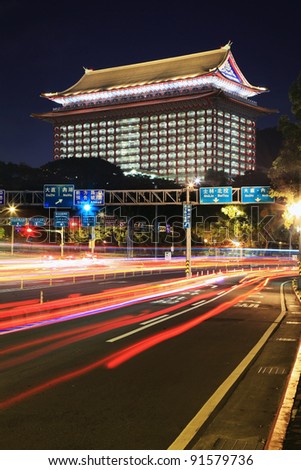 An old Chinese style hotel with busy car trails in the night
