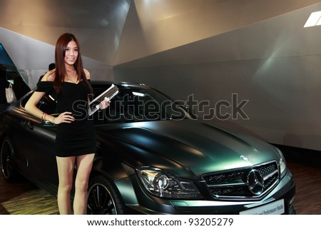 TAIPEI - JAN 1: Female presenter model with Mercedes-Benz C 63 AMG Coupe\' Performance car on display at the 19th TAIPEI INT\'L AUTO SHOW on January 1, 2012 in Taipei Taiwan