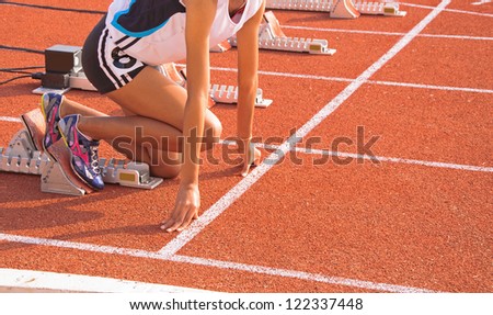 Athletic woman in start position, to run.