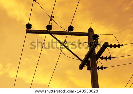Silhouettes of High voltage pole and power lines on sunset