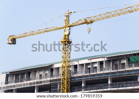Yellow hoisting crane in site