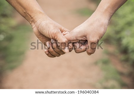 Hand of mother holding the hand of teen daughter