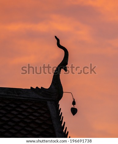 Silhouette of gable apex on the roof of Thai temple in sunset