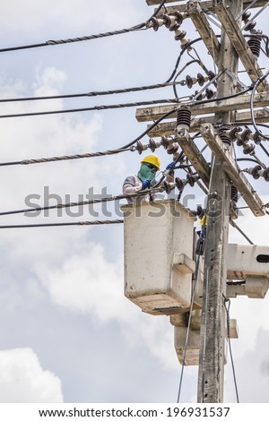 Electrical worker in a bucket fixes a problem with a power line.