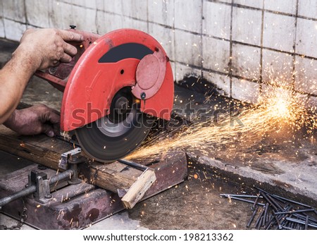 Metal cutting sawing with sparks with man in action