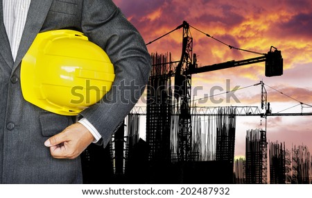 Worker or engineer holding yellow helmet for workers security in construction site