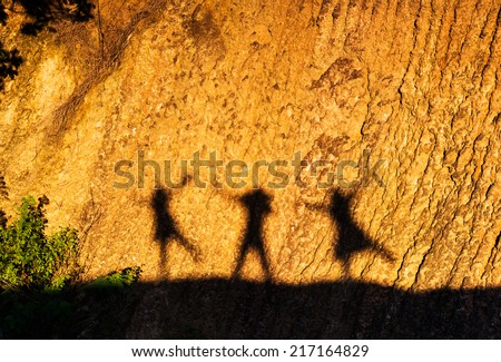 Shadow of a family on a earth wall