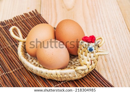 Brown chicken eggs in basket isolated on wood background