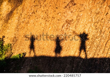 Shadow of a family on a earth wall