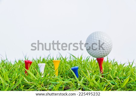 Golf ball on green grass against white background.