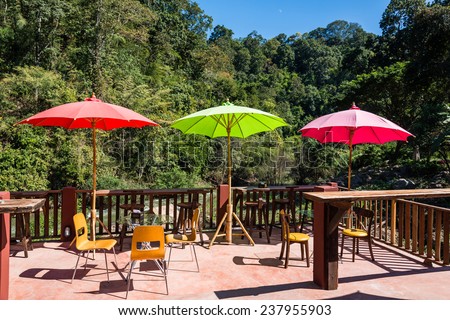 Terrace with parasol and chairs with view on river and mountains