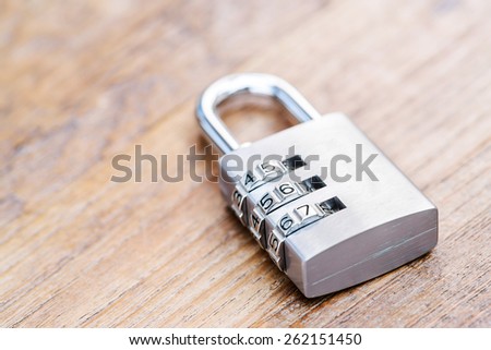 Combination padlock close up with chrome numbers on wooden background