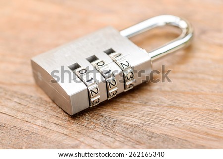 Combination padlock close up with chrome numbers on wooden background