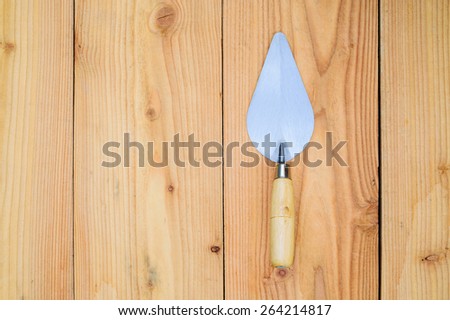 Close up steel trowel isolated on wood floor background