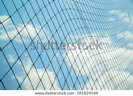 Seamless mesh fence in football stadium on blue sky.