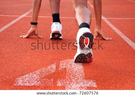 Athletic man on track starting to run