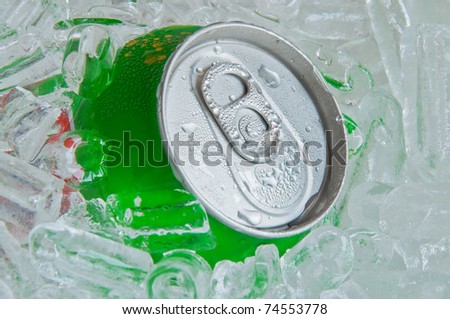 Cans of soft drink, cooling frozen and with water drops in ice background