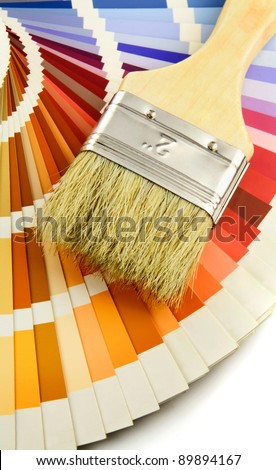 A paint brush and colorful paint swatches on white background.